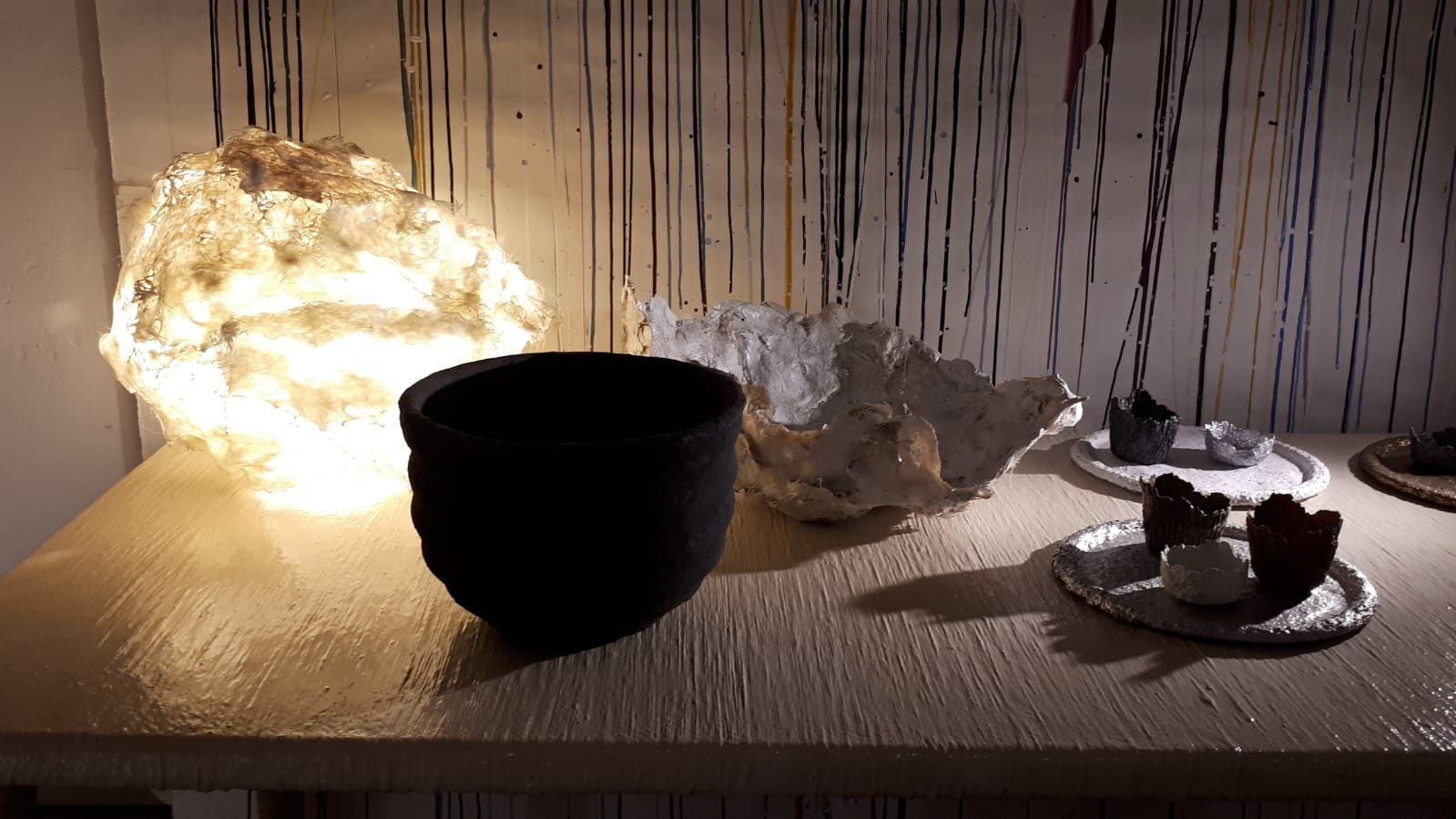 Lampada scultorea luminosa e ceramiche artigianali esposte nello showroom Bistolfi