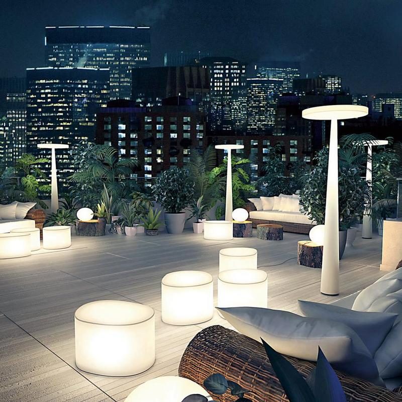 Lampade da esterno luminose su una terrazza di notte, con lo skyline della città illuminato sullo sfondo