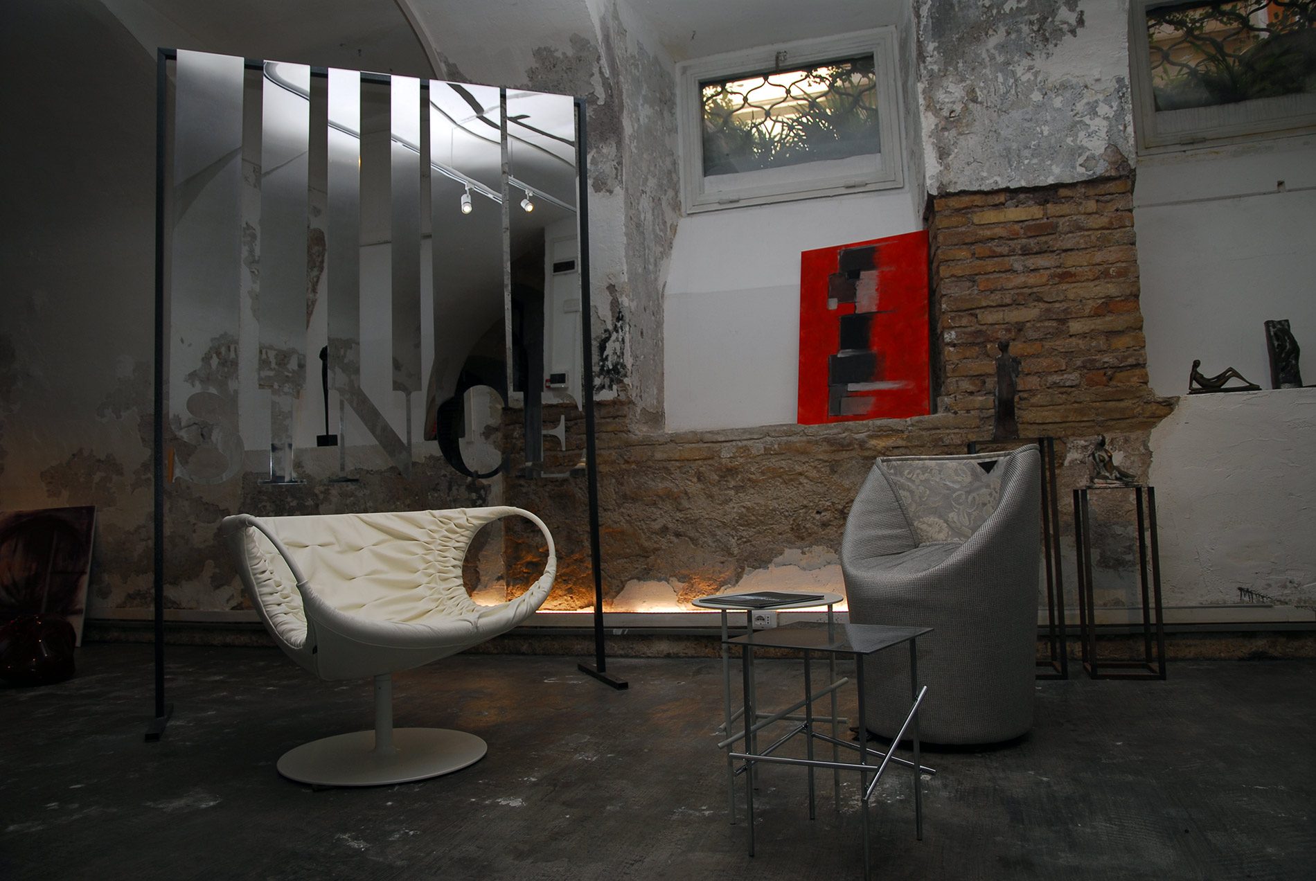 Poltrona di design su muro in pietra a vista, nello showroom Bistolfi